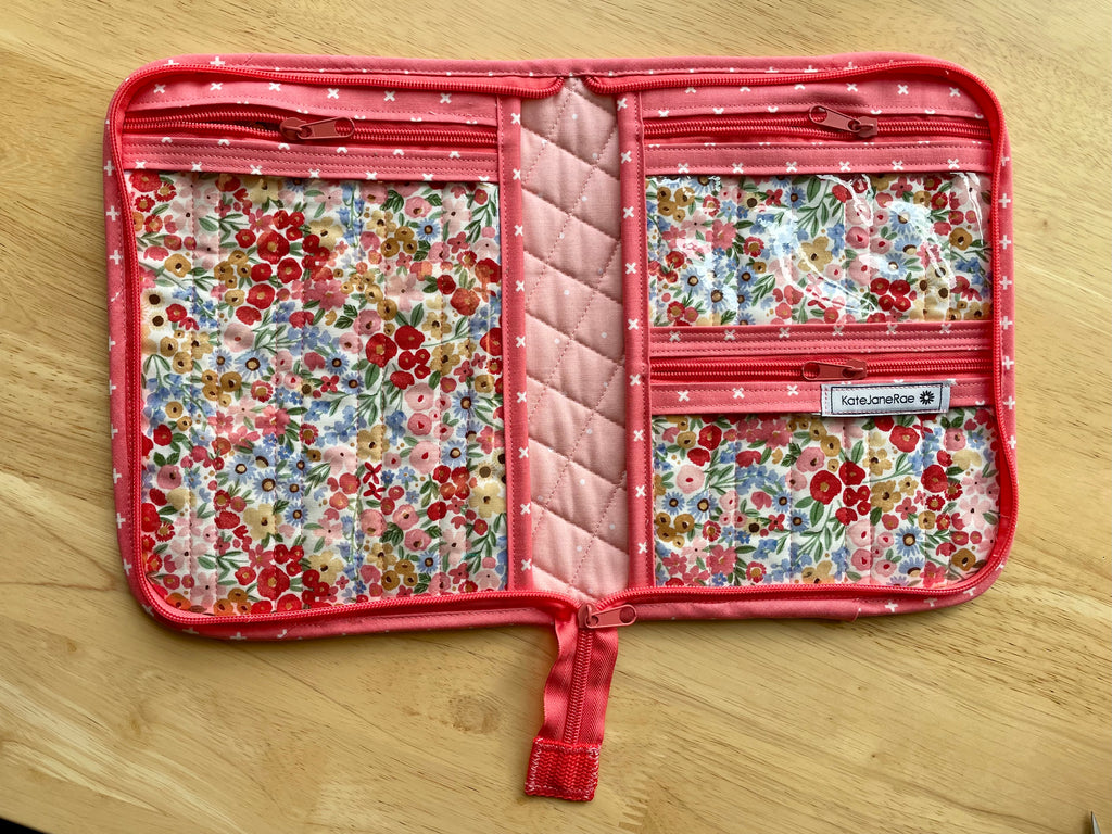 Floral-patterned travel organizer on a wooden surface