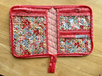 Floral-patterned travel organizer on a wooden surface