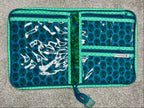 Open teal and white patterned wallet on a gray surface