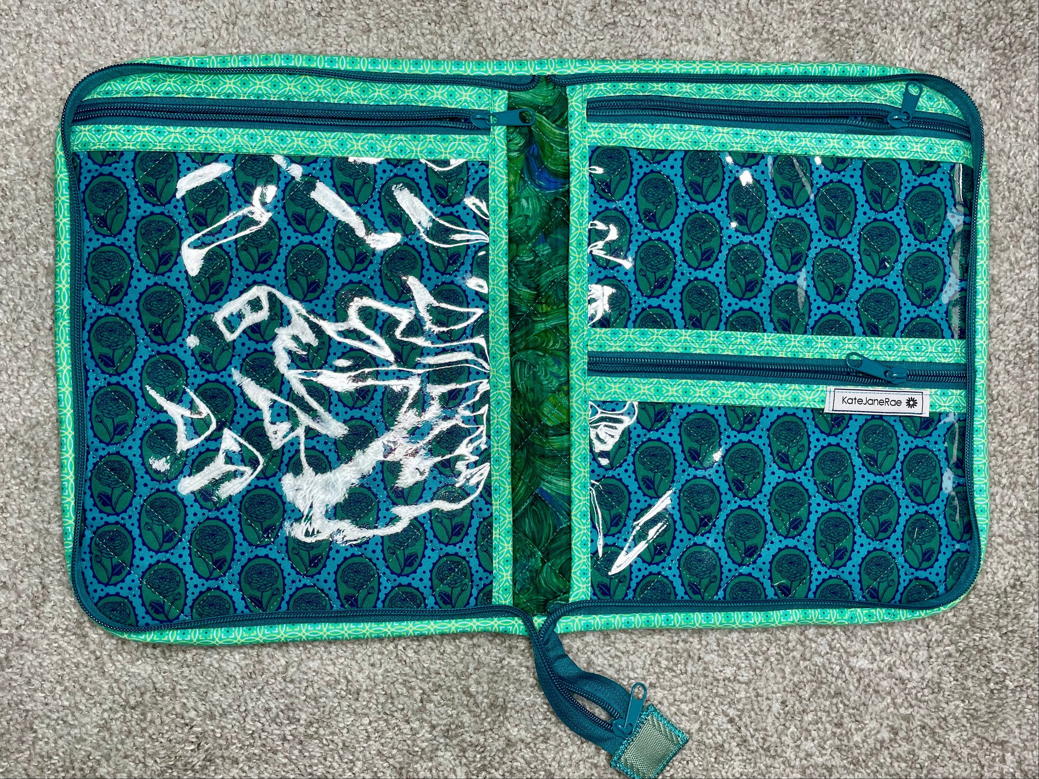 Open teal and white patterned wallet on a gray surface