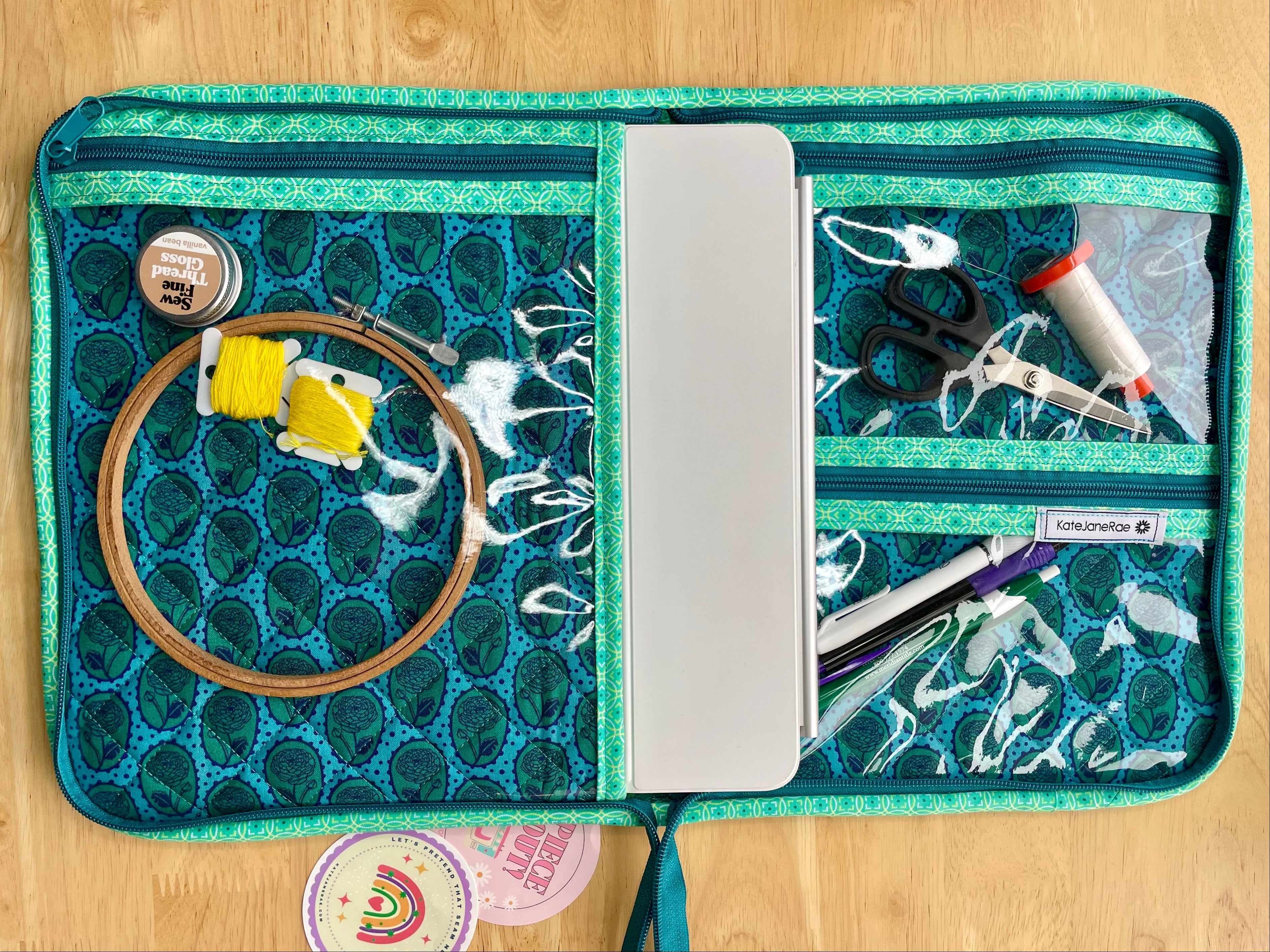 Green sewing kit with various tools on a wooden surface