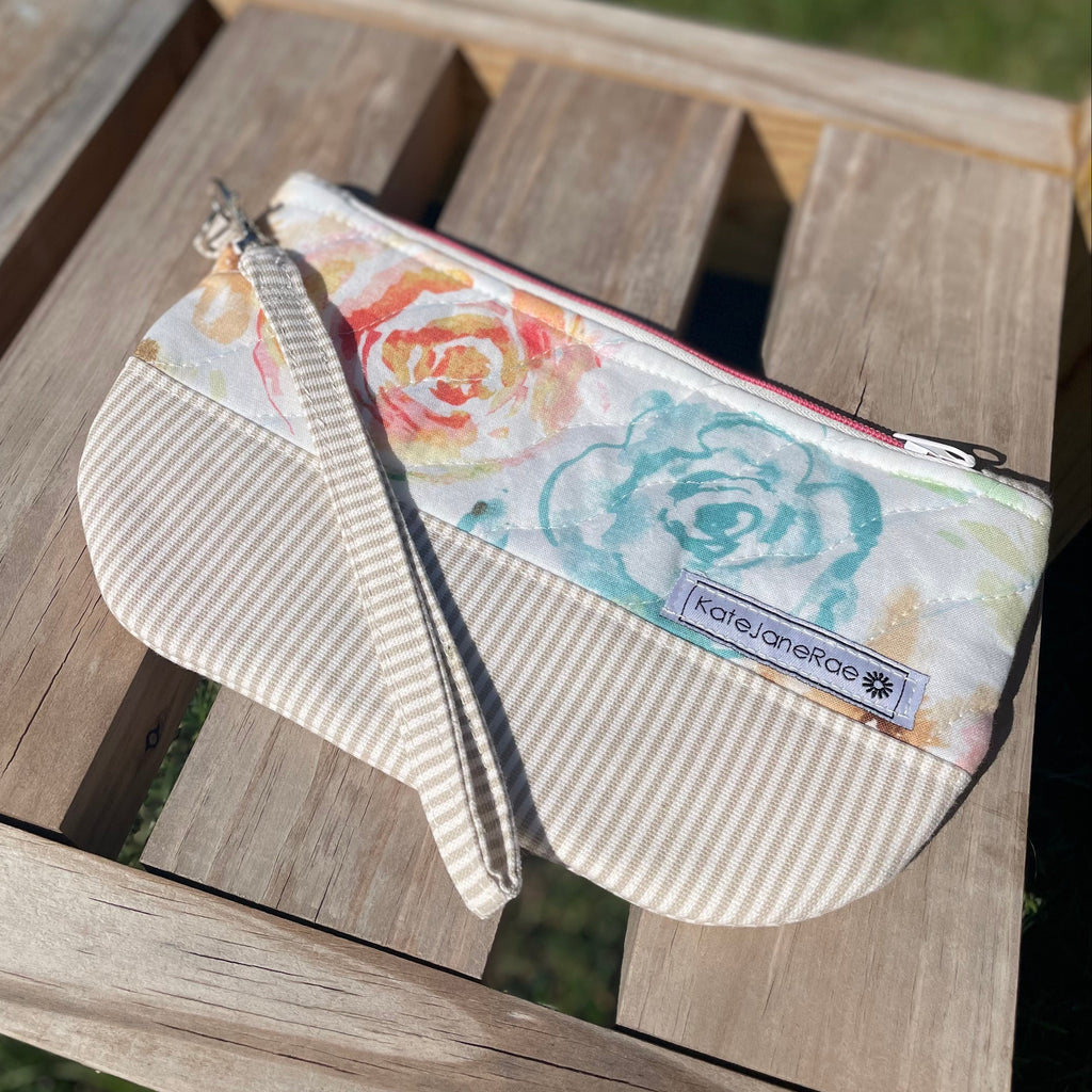 Medium zipper pouch with floral designs on a wooden surface
