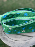 Green quilted bag with blue paw print pattern on a green background