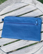 Blue pouch on a wooden chair with grass background