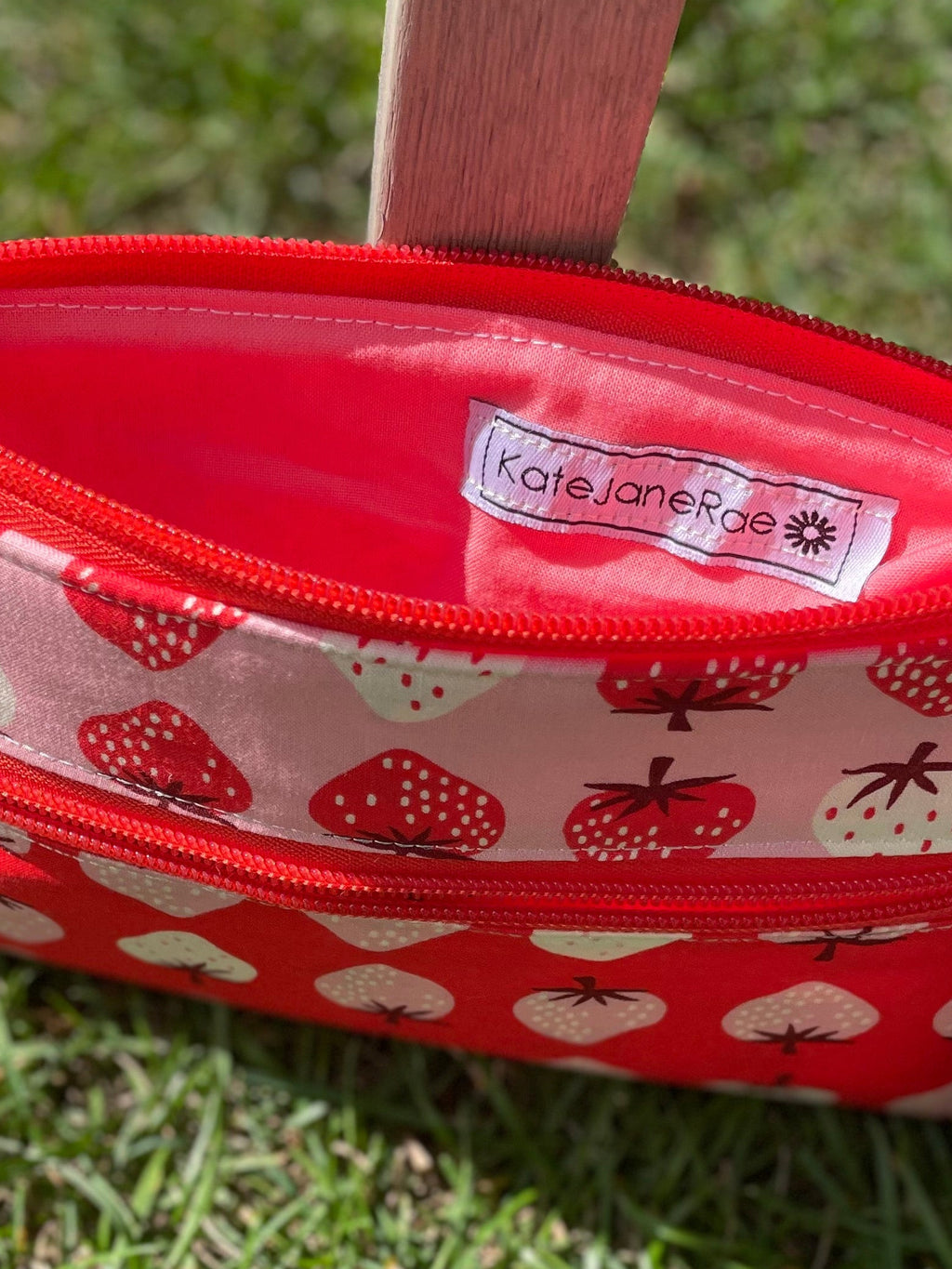 Red pouch with white pattern on grass