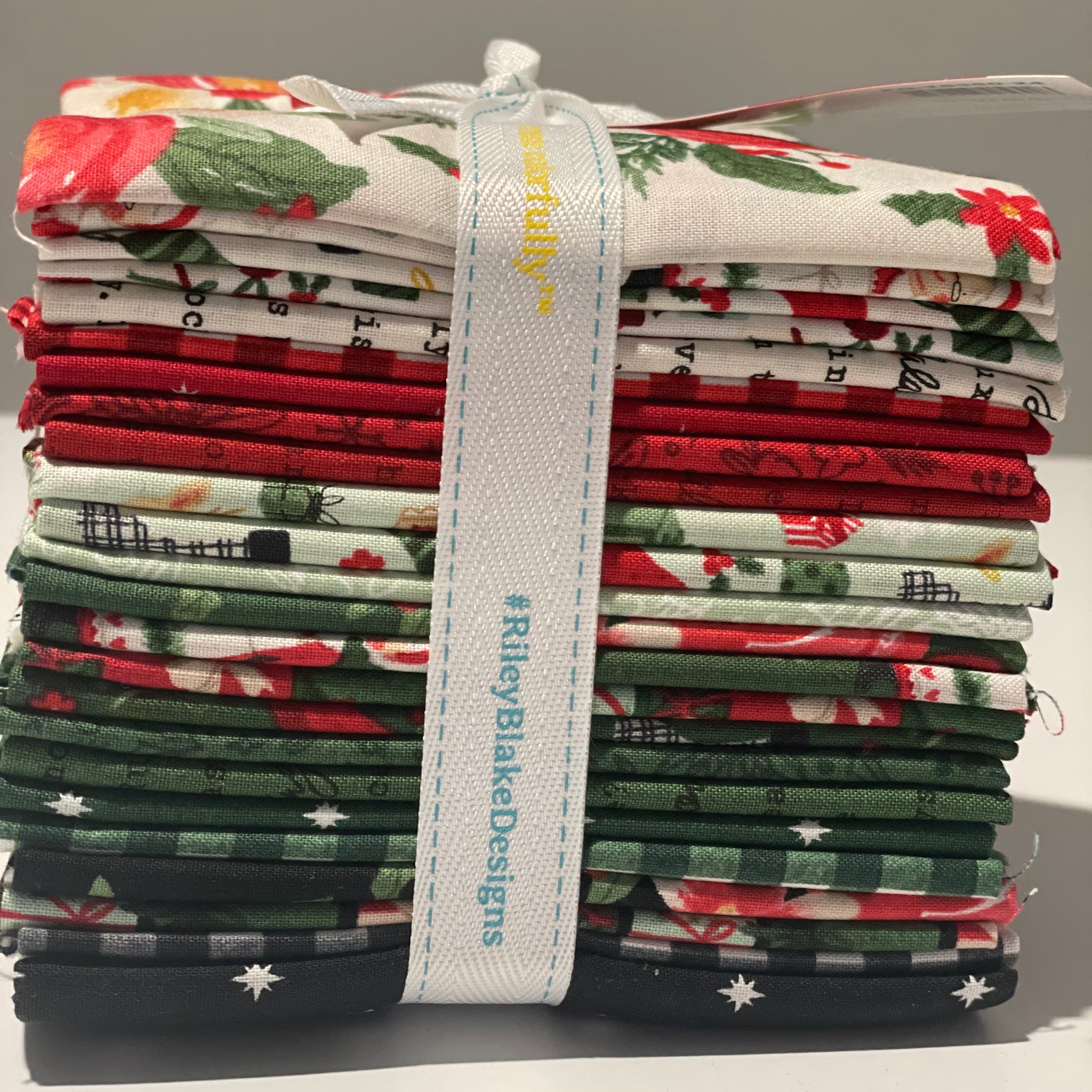 Roll of fabric strips with a 'Riley Blake Designs' label on a gray background