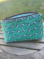 Small green pouch on wooden table.