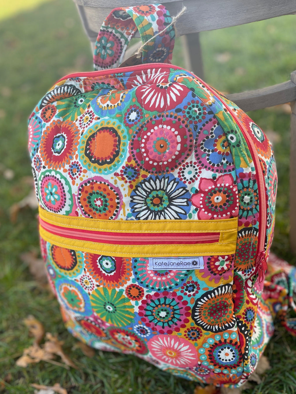 Colorful floral-patterned backpack on a grassy surface