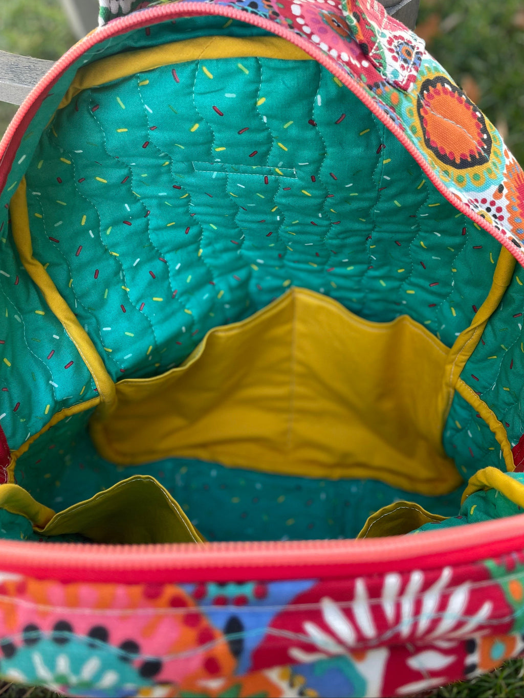 Colorful fabric bag with a patterned interior on a grassy background