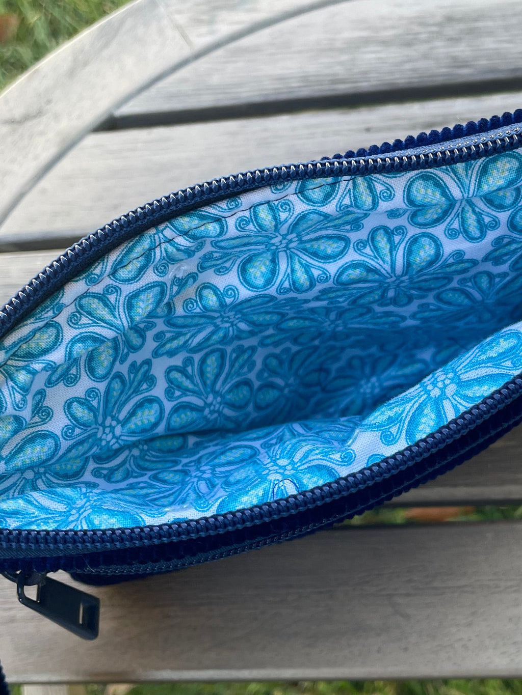 Blue pouch with floral pattern on a wooden surface