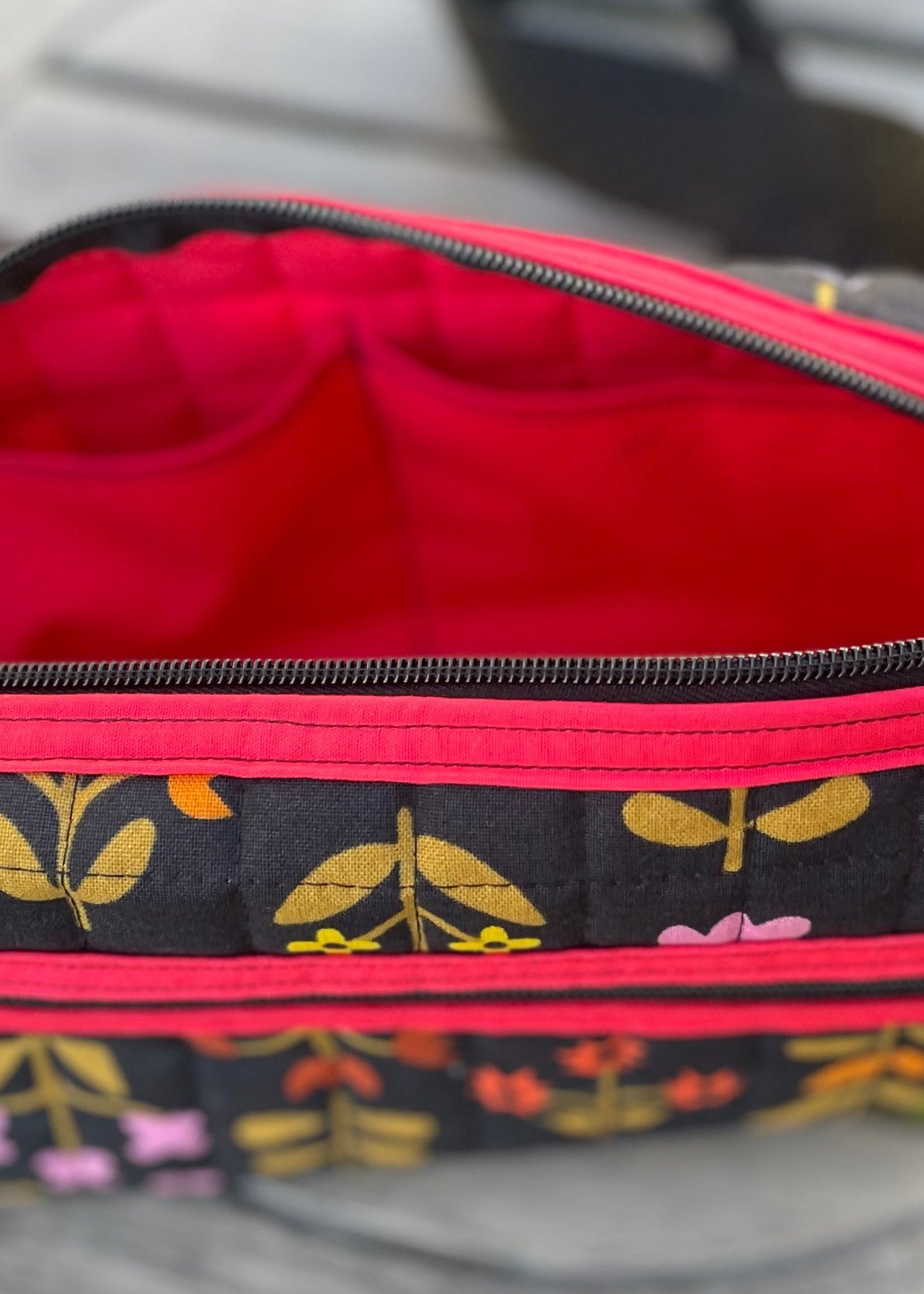 Open bag with floral patterned pouch on grass