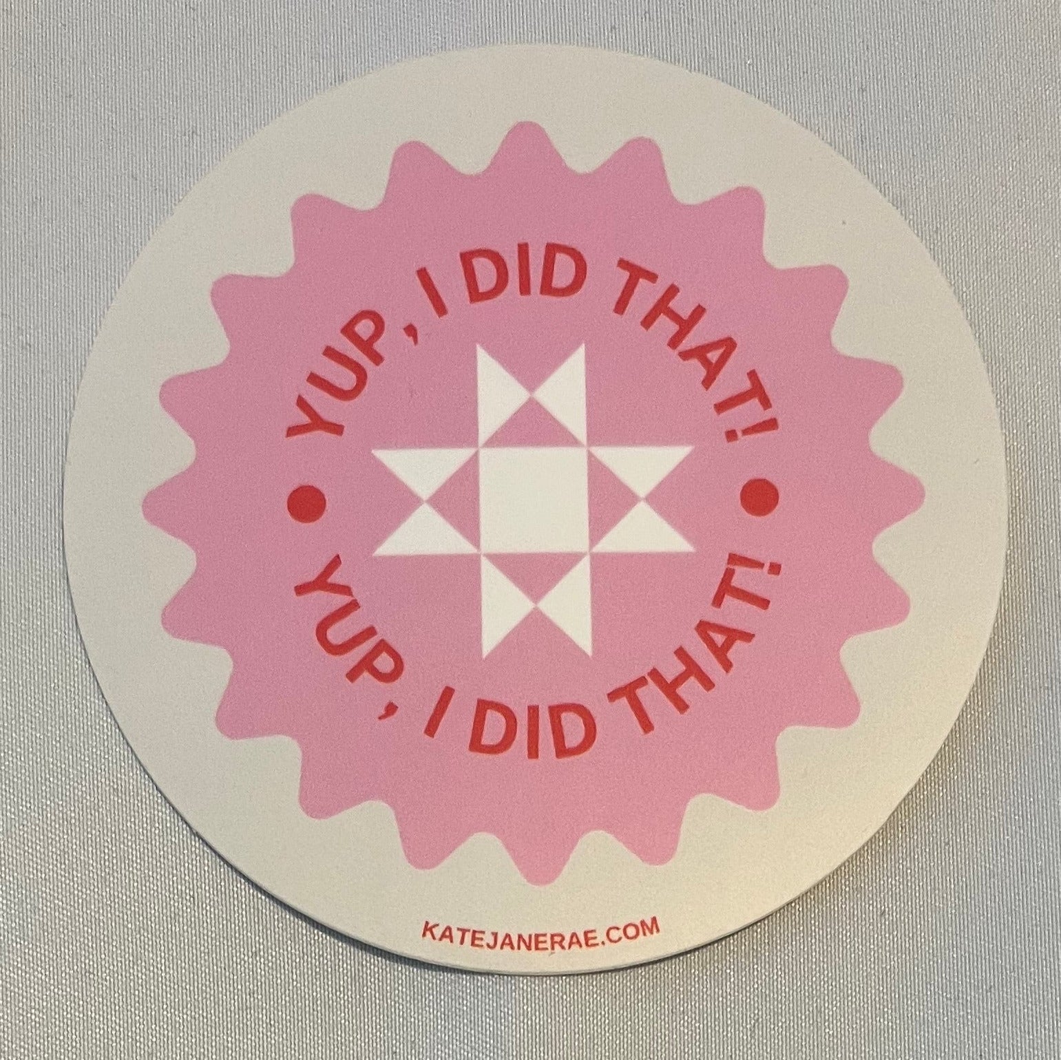 Pink sticker with text on a beige background