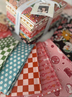 Stack of colorful fabric bundles with a visible brand tag on a white surface.