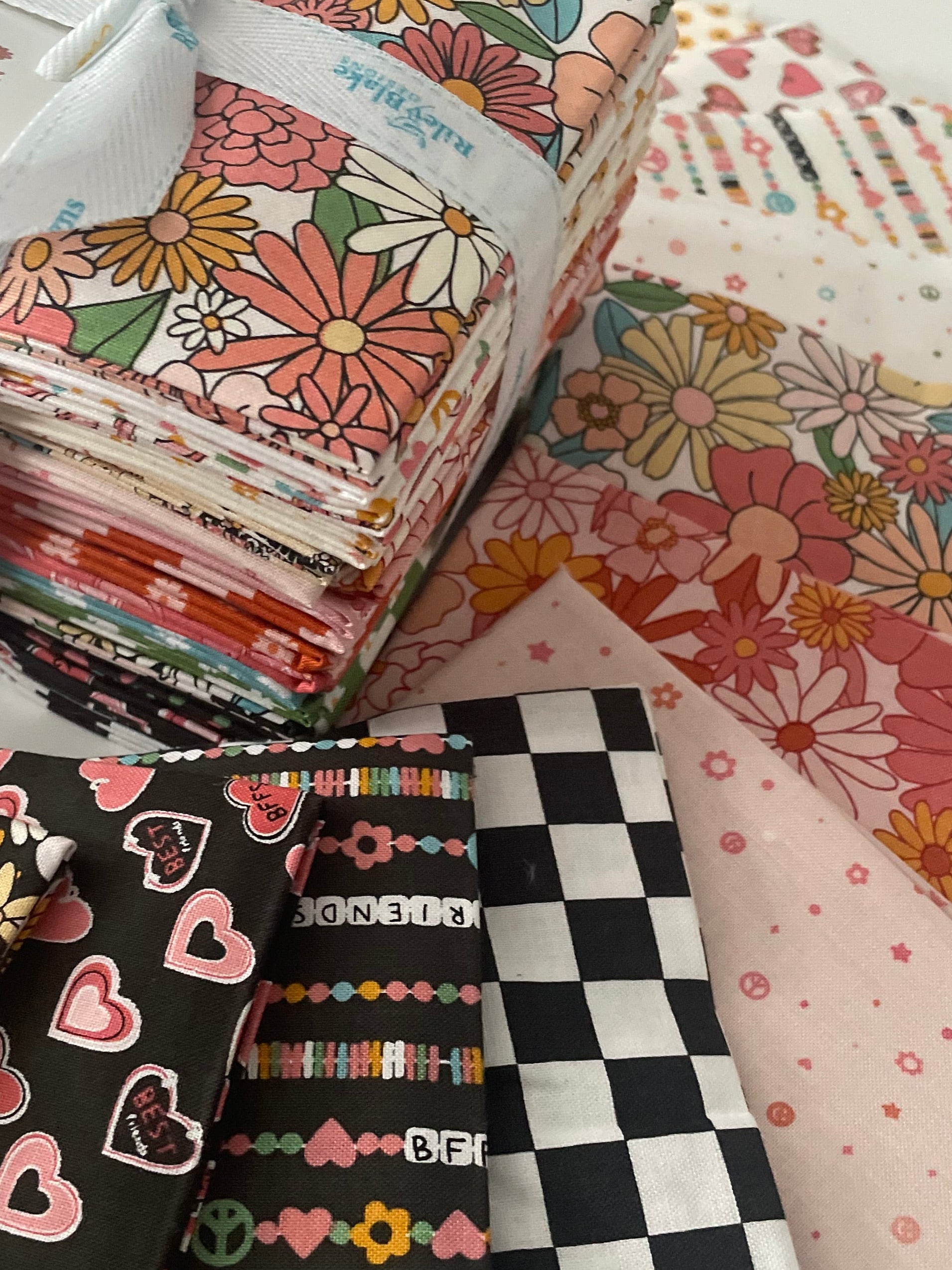 Collection of patterned fabric bundles with a white ribbon on a light background