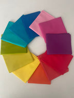 Colorful square cloths arranged in a circular pattern on a white background