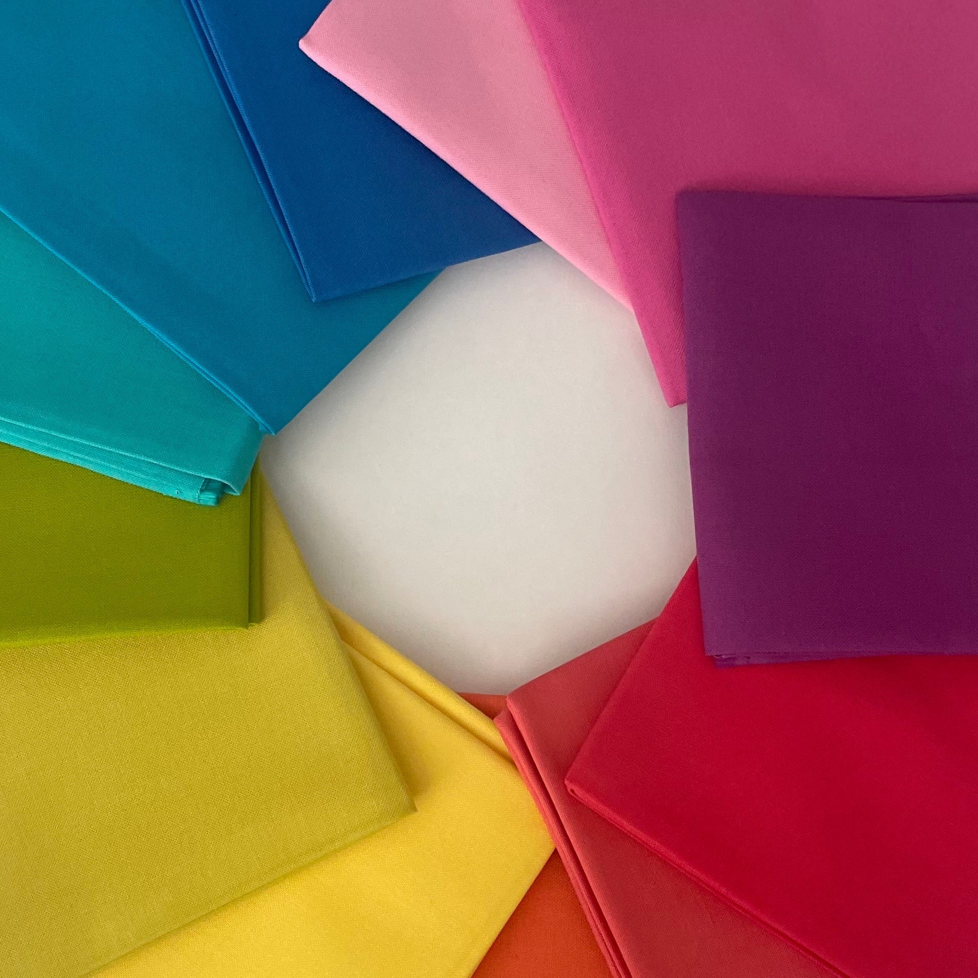 Colorful square sheets arranged in a circular pattern on a white background
