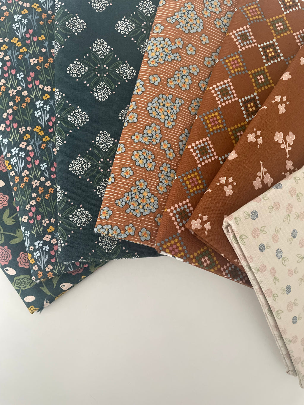 Three pieces of patterned fabric on a white surface