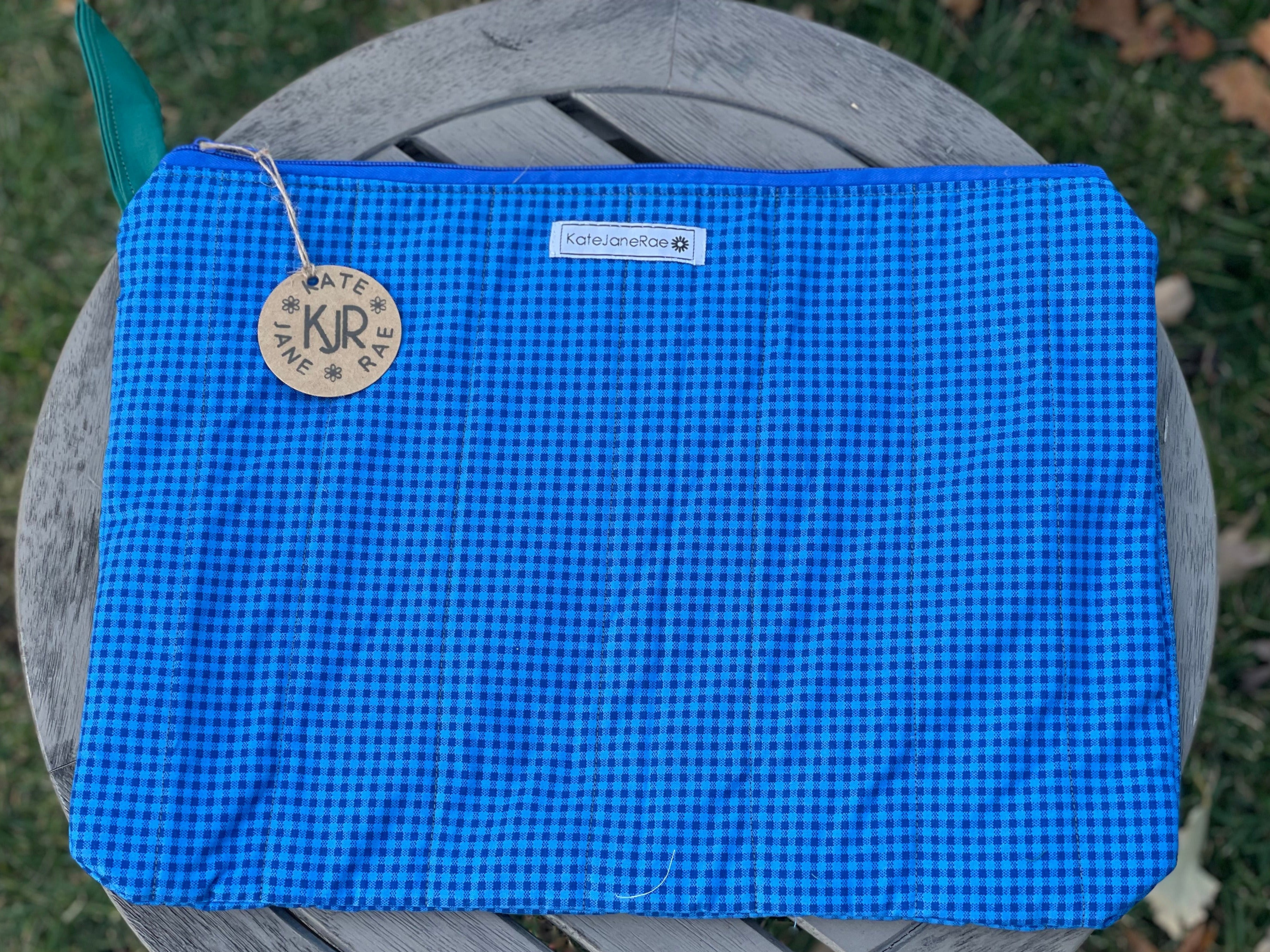 Blue textured bag with a brand tag on a gray surface outdoors