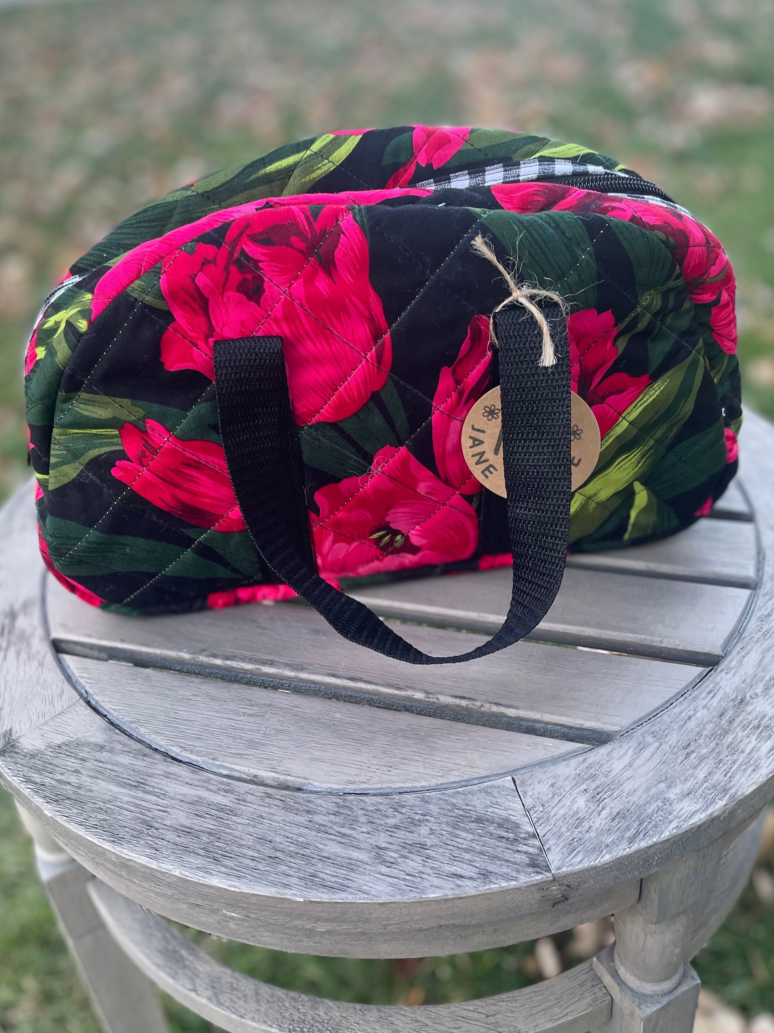 Floral-patterned bag on a wooden stool outdoors