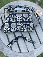 Black and white floral-patterned bag on a wooden stool outdoors