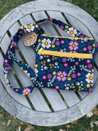 Floral-patterned pouch with a strap on a wooden surface