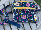 Floral-patterned pouch with strap on a wooden surface