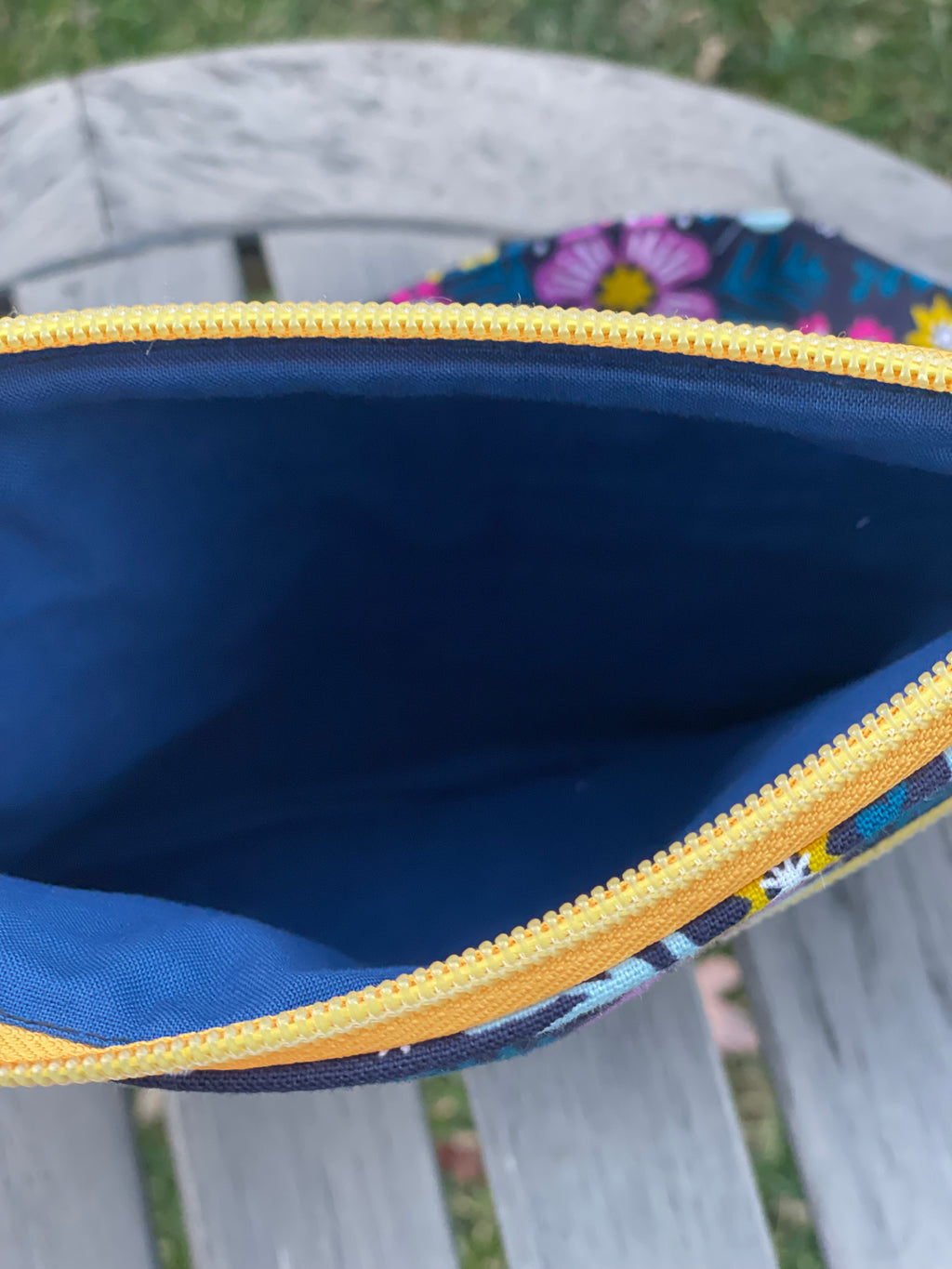 Close-up of a blue pouch with floral patterned edge, outdoors.