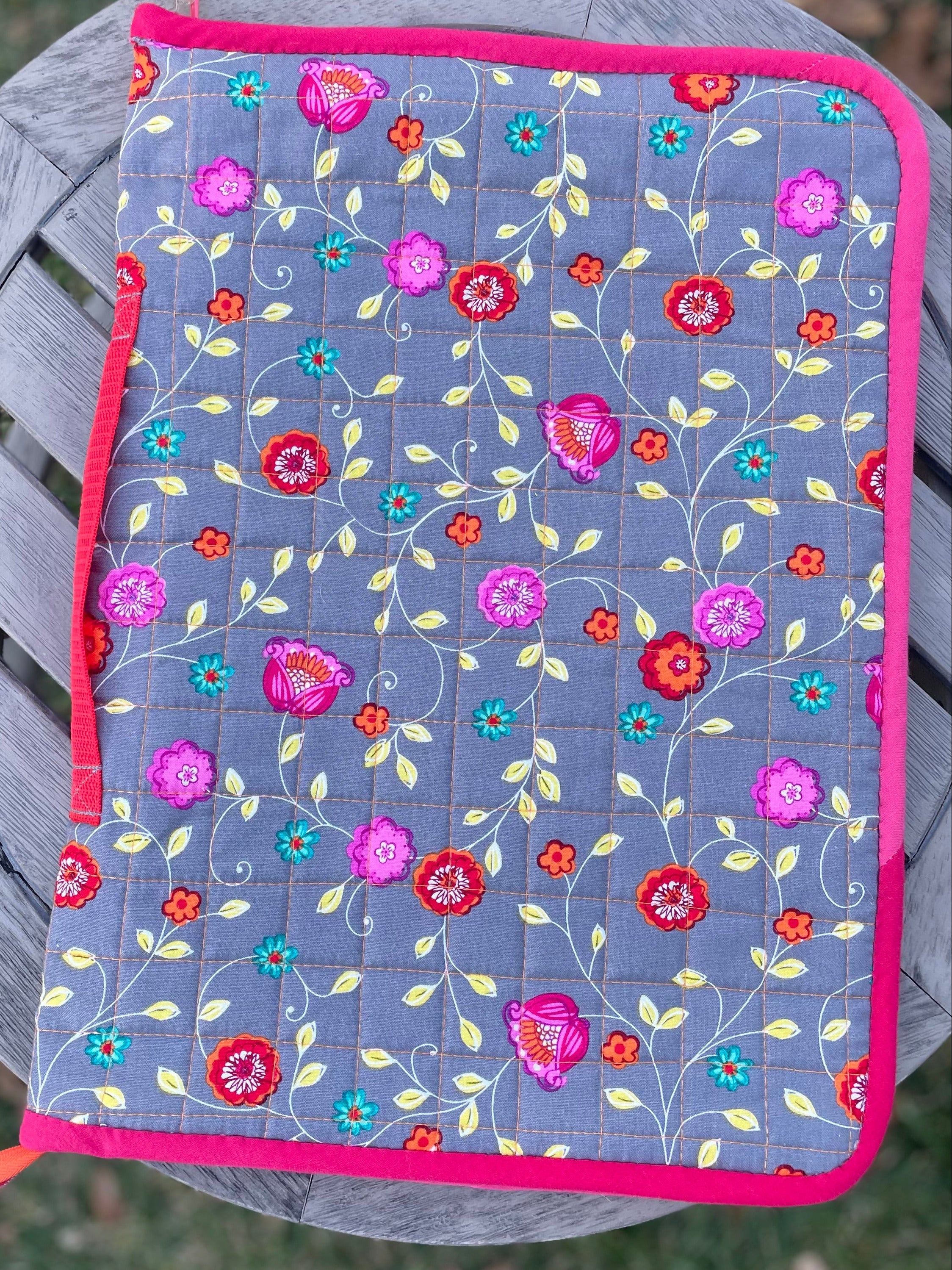 Floral patterned pot holder on a metal chair outdoors