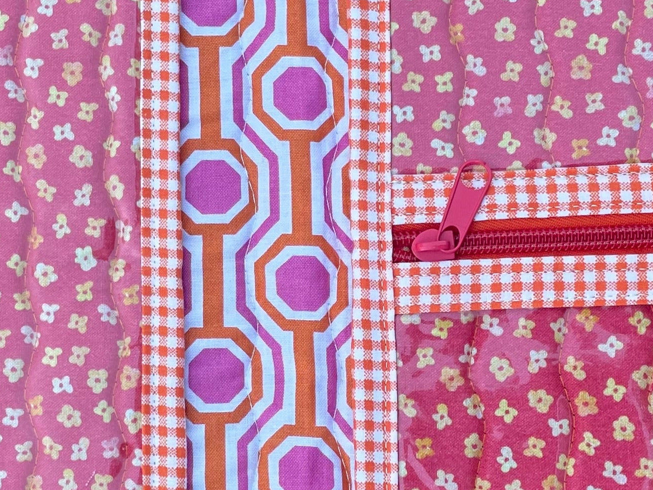 Pink fabric pouch with floral patterns on a wooden surface