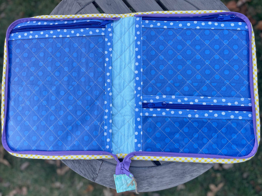 Blue quilted pouch with a pattern on a grassy background
