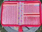 Pink fabric pouch with a zipper on a wooden surface