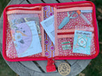 Fabric wallet with various items on a wooden surface
