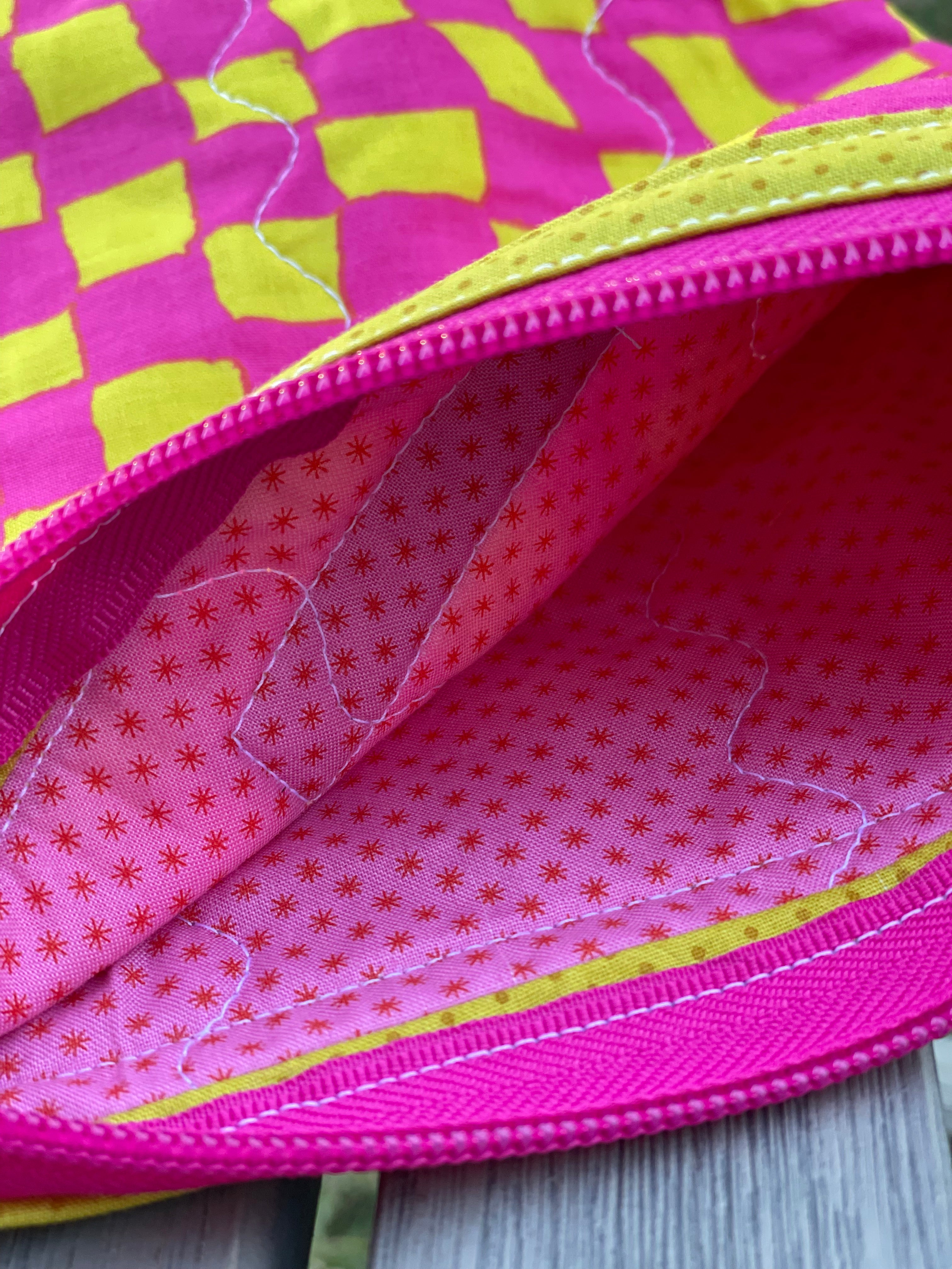 Close-up of a pink and yellow textured fabric with a zipper