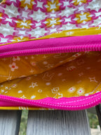 Close-up of colorful fabric with star patterns and a pink zipper.