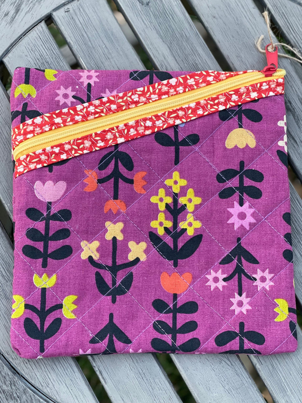 Purple fabric pouch with floral patterns on a wooden surface