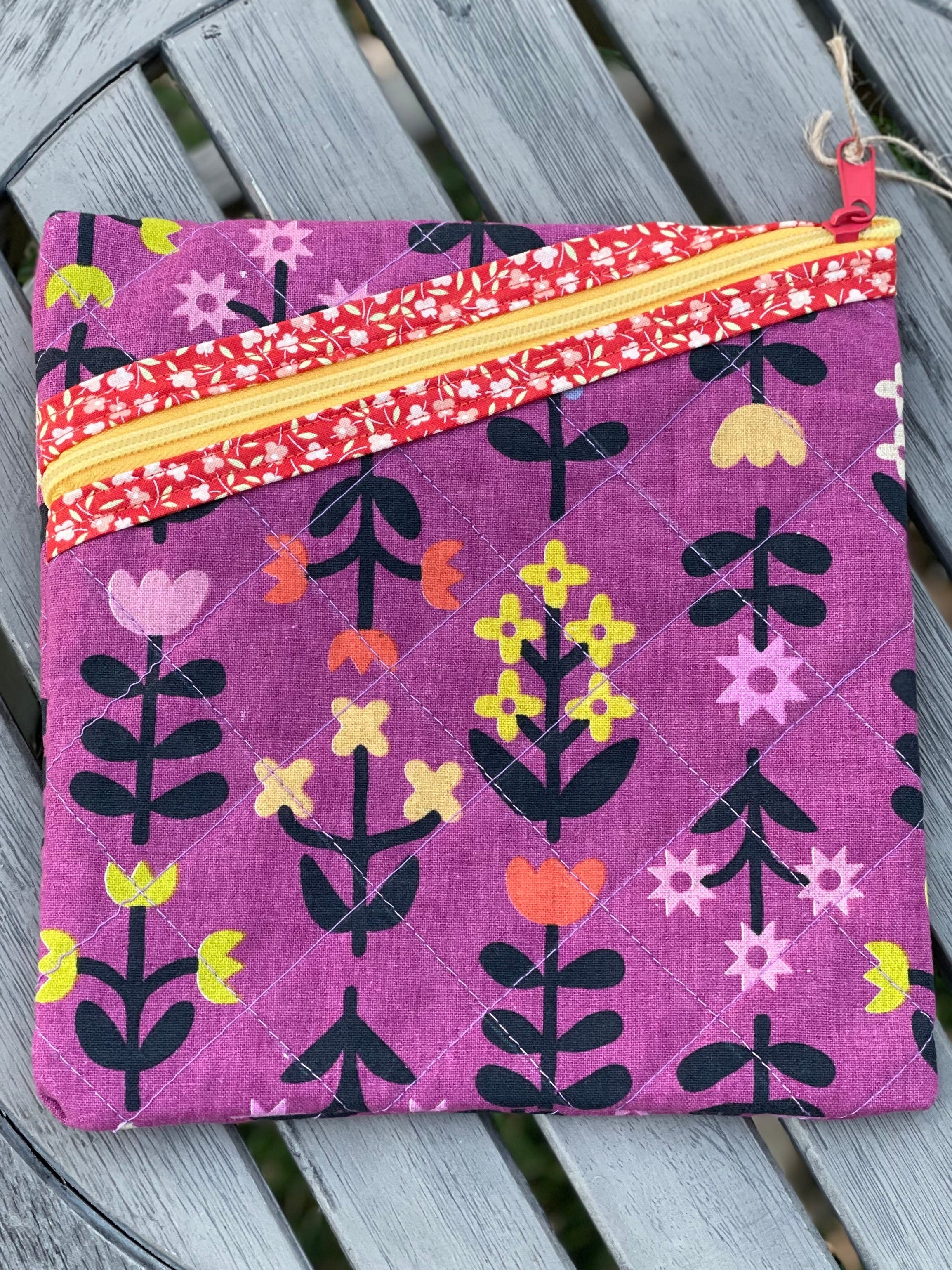 Purple fabric pouch with floral patterns on a wooden surface