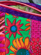 Colorful floral-patterned pouch with a purple zipper on a wooden surface