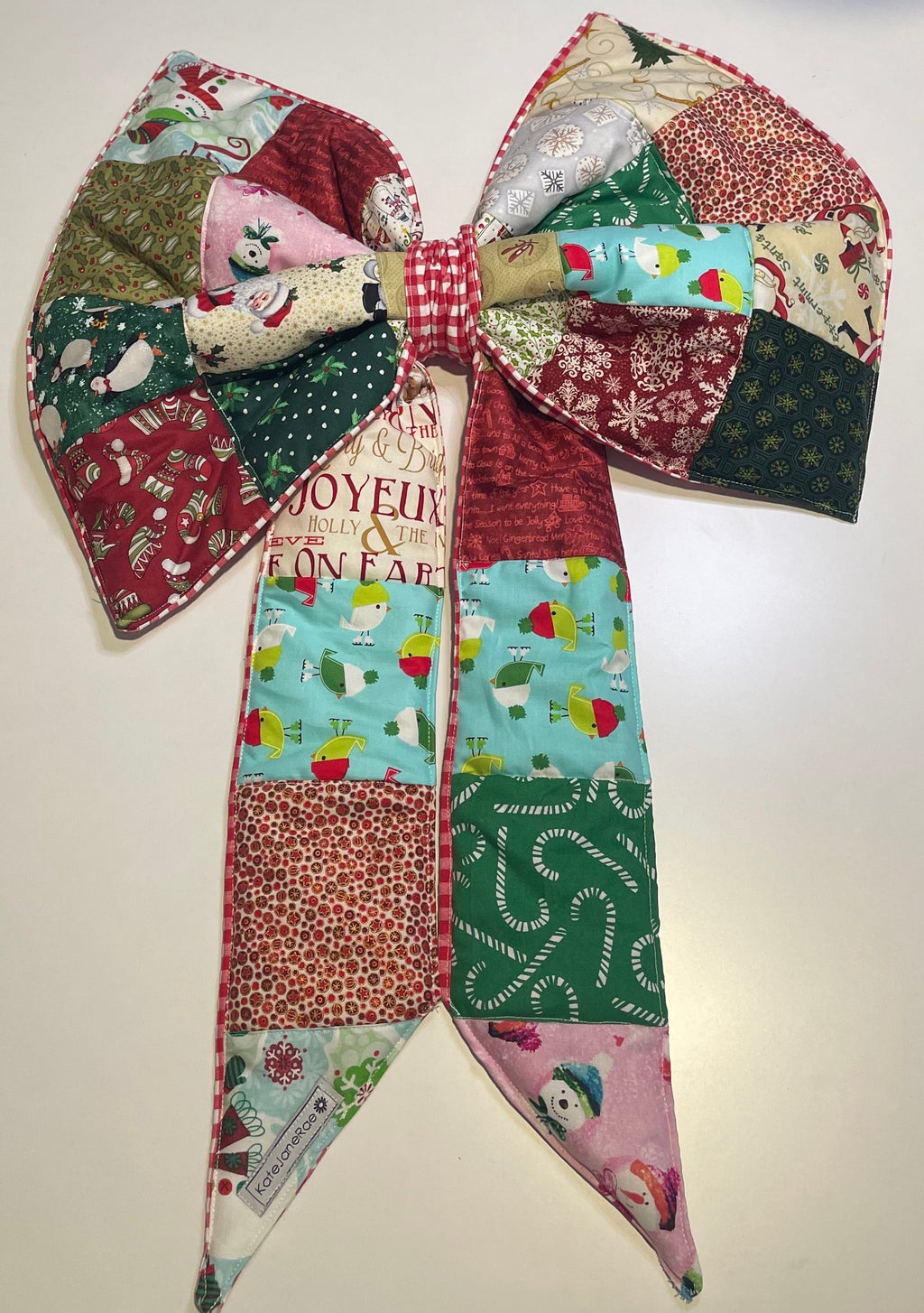 Colorful patchwork bow with festive patterns on a light background