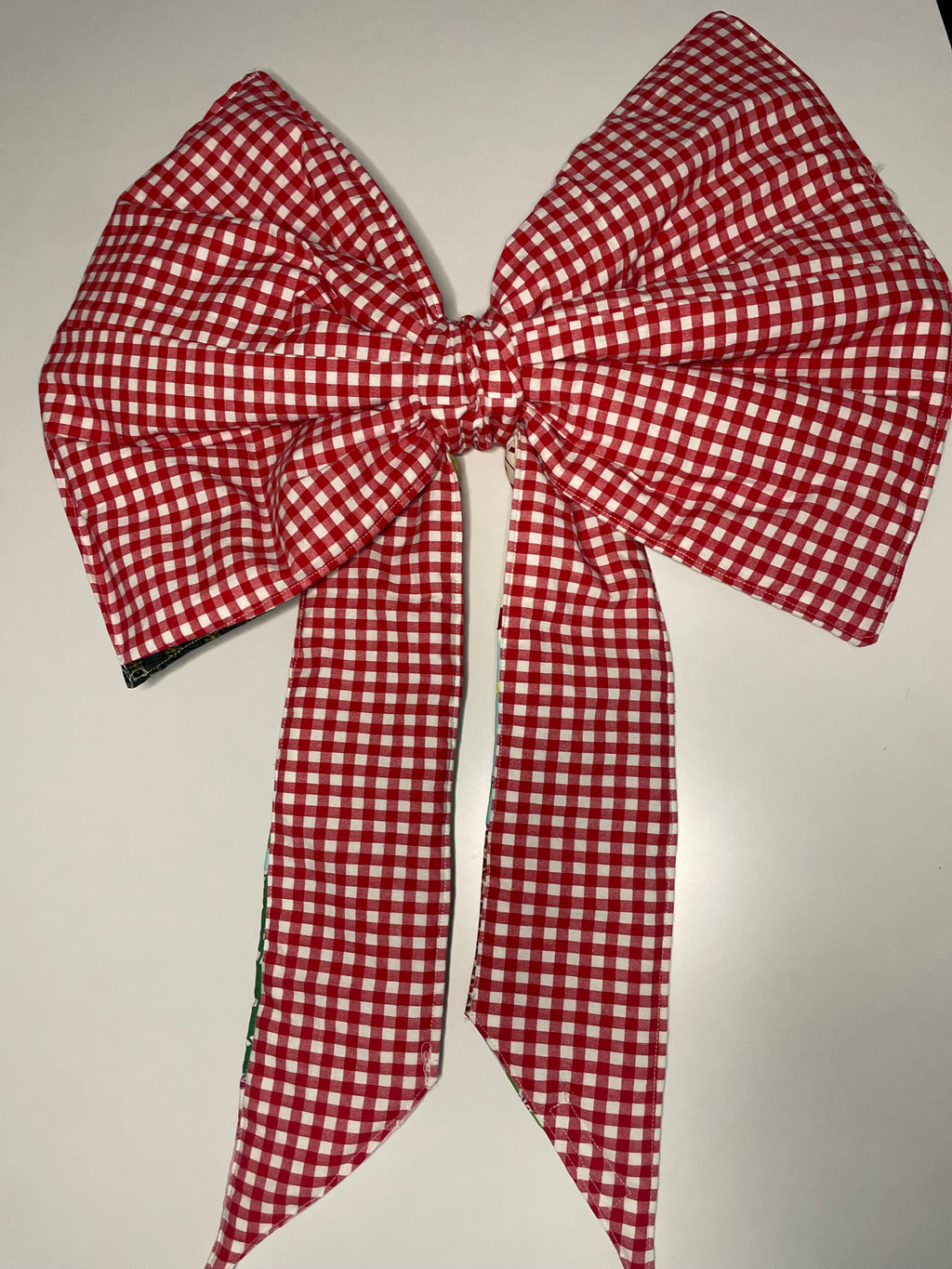 Red and white checkered bow on a light gray background