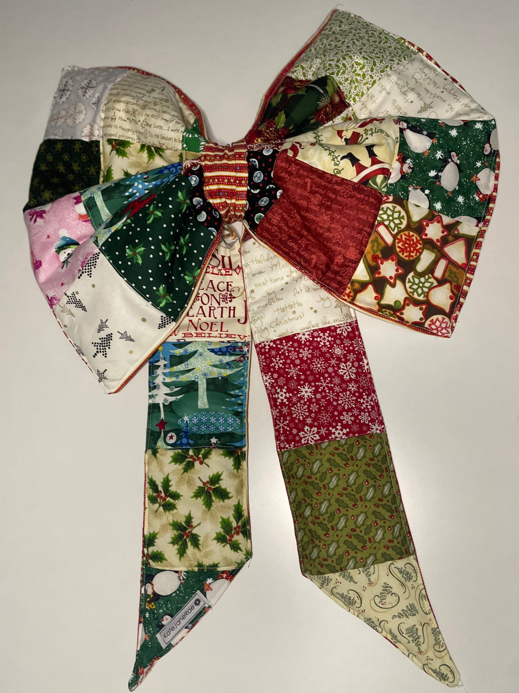 Patchwork bow with Christmas-themed fabric on a white background