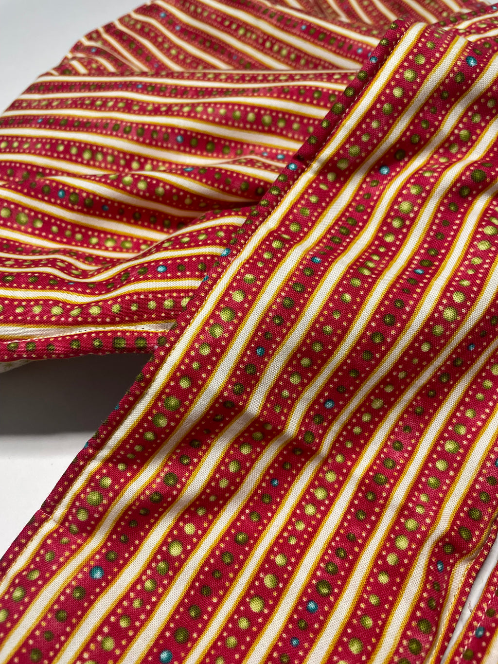 Close-up of a red fabric with gold and multicolor pattern