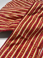 Close-up of a red fabric with gold and multicolor pattern