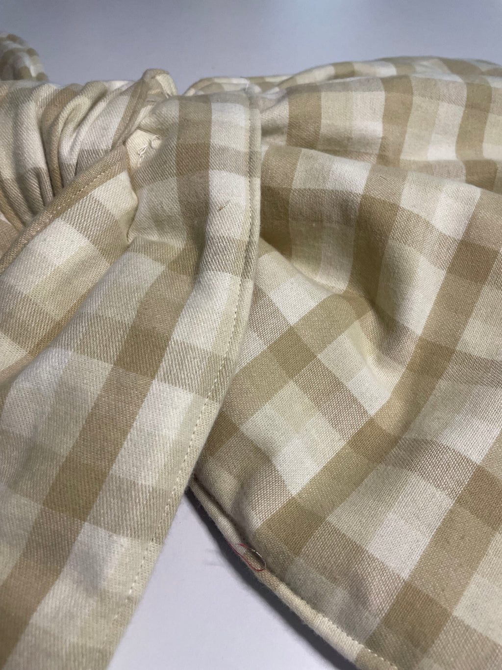 Close-up of a beige and white checkered fabric with a blurred background