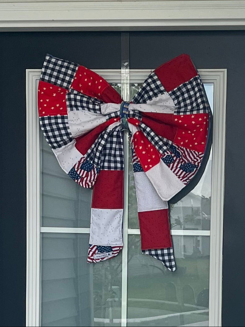 Front door with a decorative plate featuring a quilt design and a 'Welcome' mat.