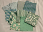 Collection of green fabric samples with various patterns on a white background