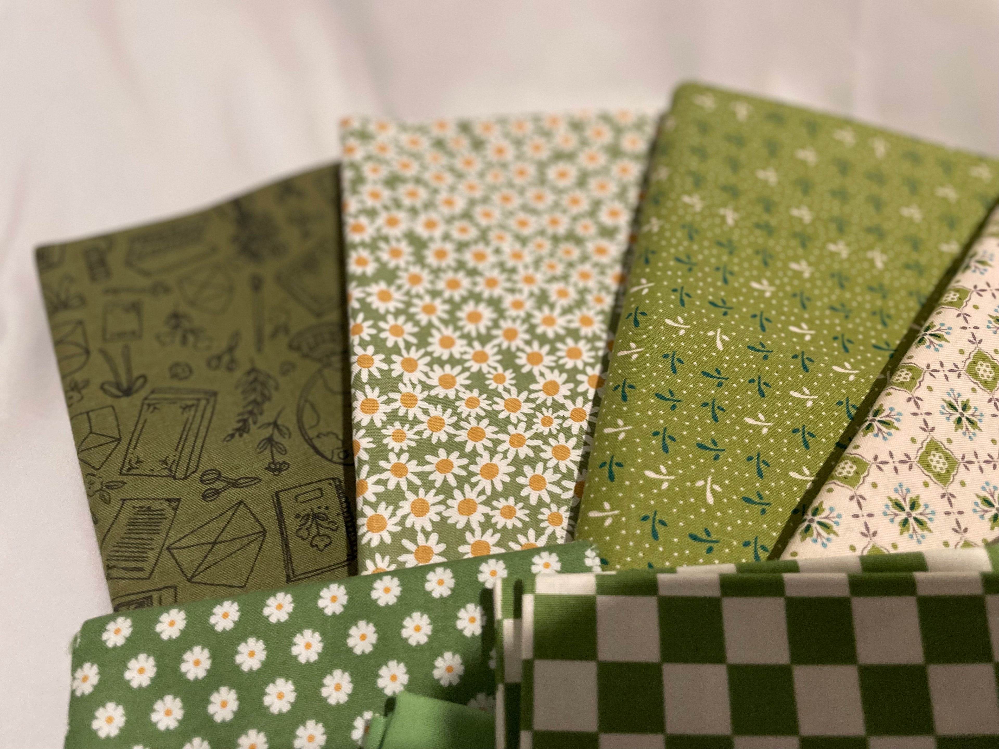Collection of green patterned notebooks on a white background