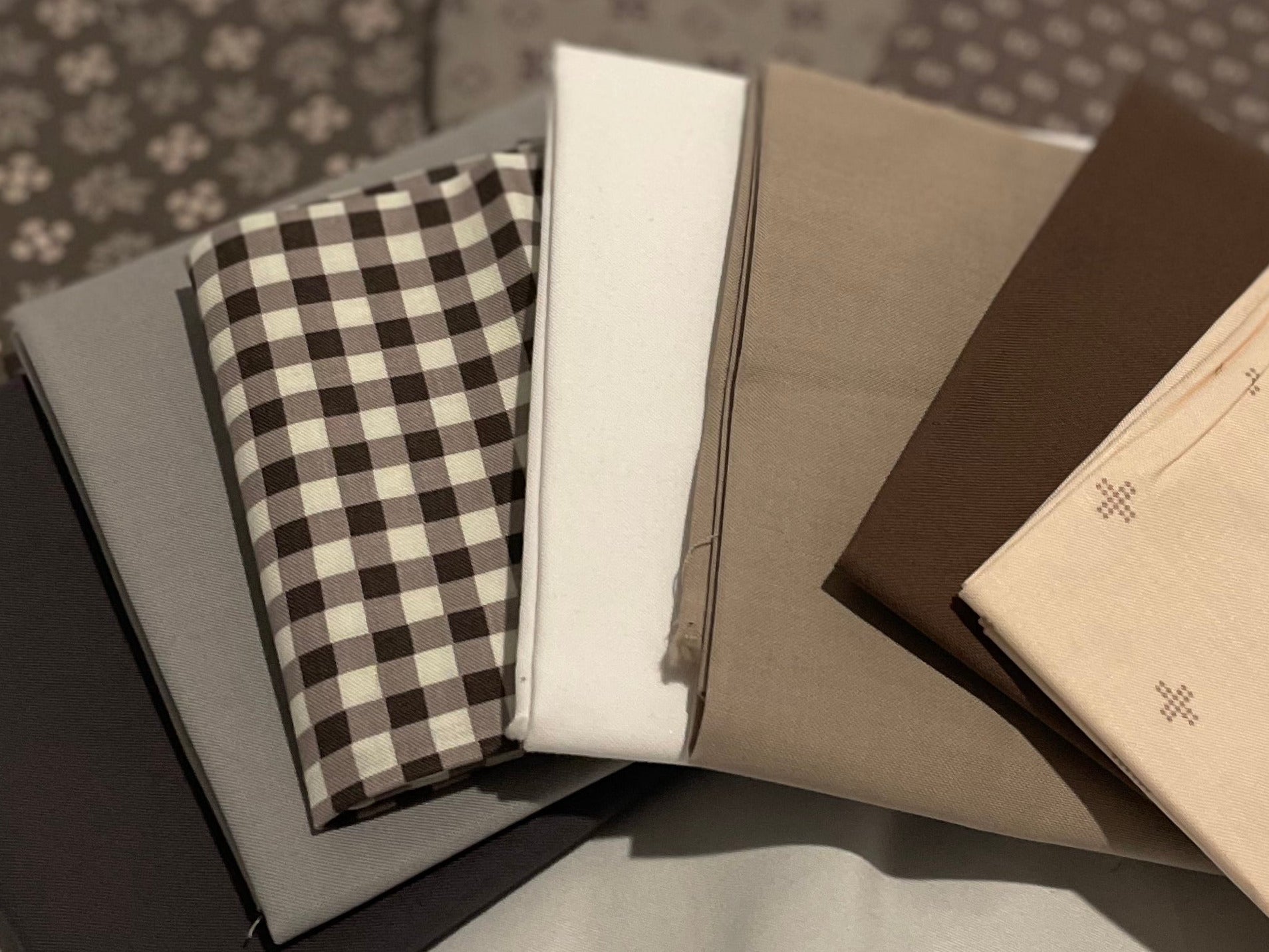 Collection of fabric swatches in various patterns and colors on a light background