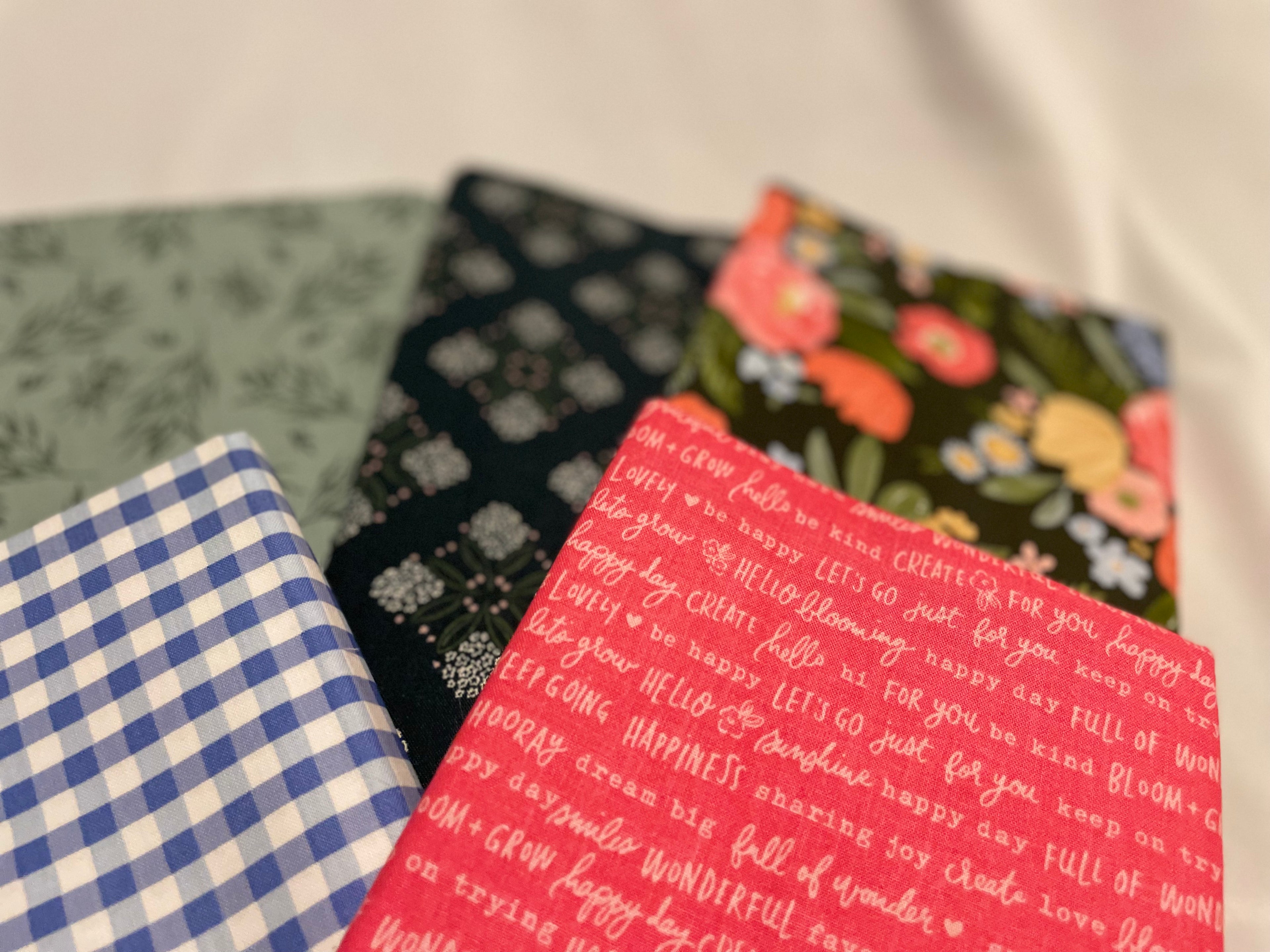 Four fabric swatches with different patterns and text on a white background