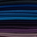 Set of folded fabric swatches in blue, purple, and navy with a label on a beige background