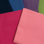 Five colorful books stacked on a beige surface